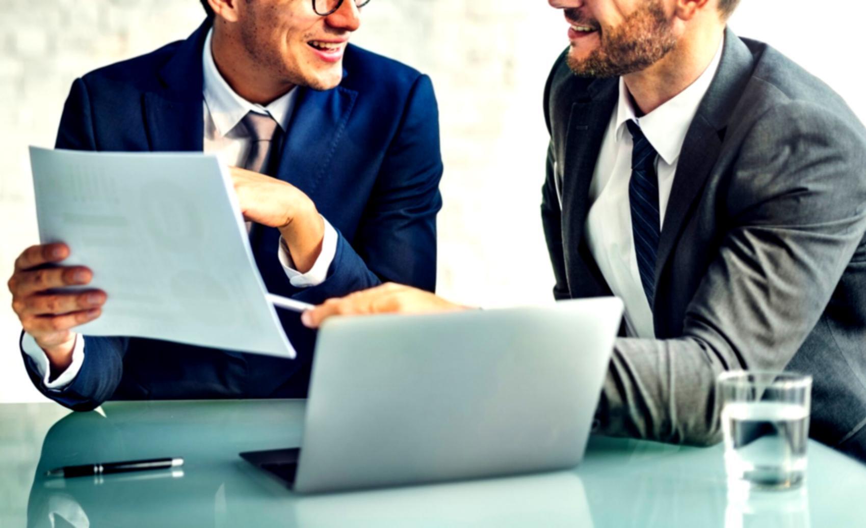 Groupe d'apprenants collaborant sur des projets financiers dans un environnement moderne et convivial